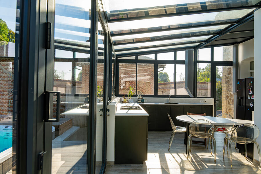 Intérieur d'une véranda aluminium avec vue sur la piscine
