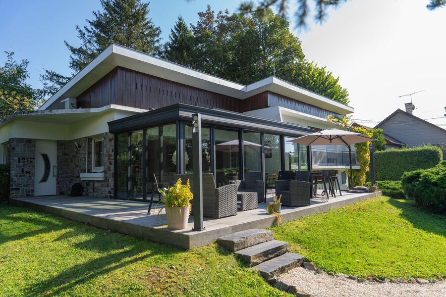 Véranda aluminium adossée à une maison, vue extérieure