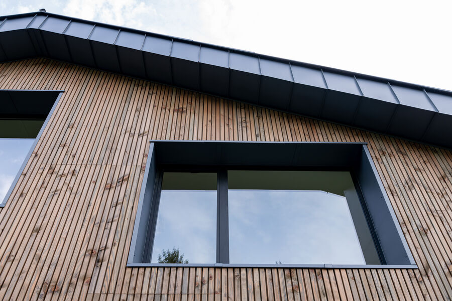 Fenêtres aluminium encastrées dans un bardage bois