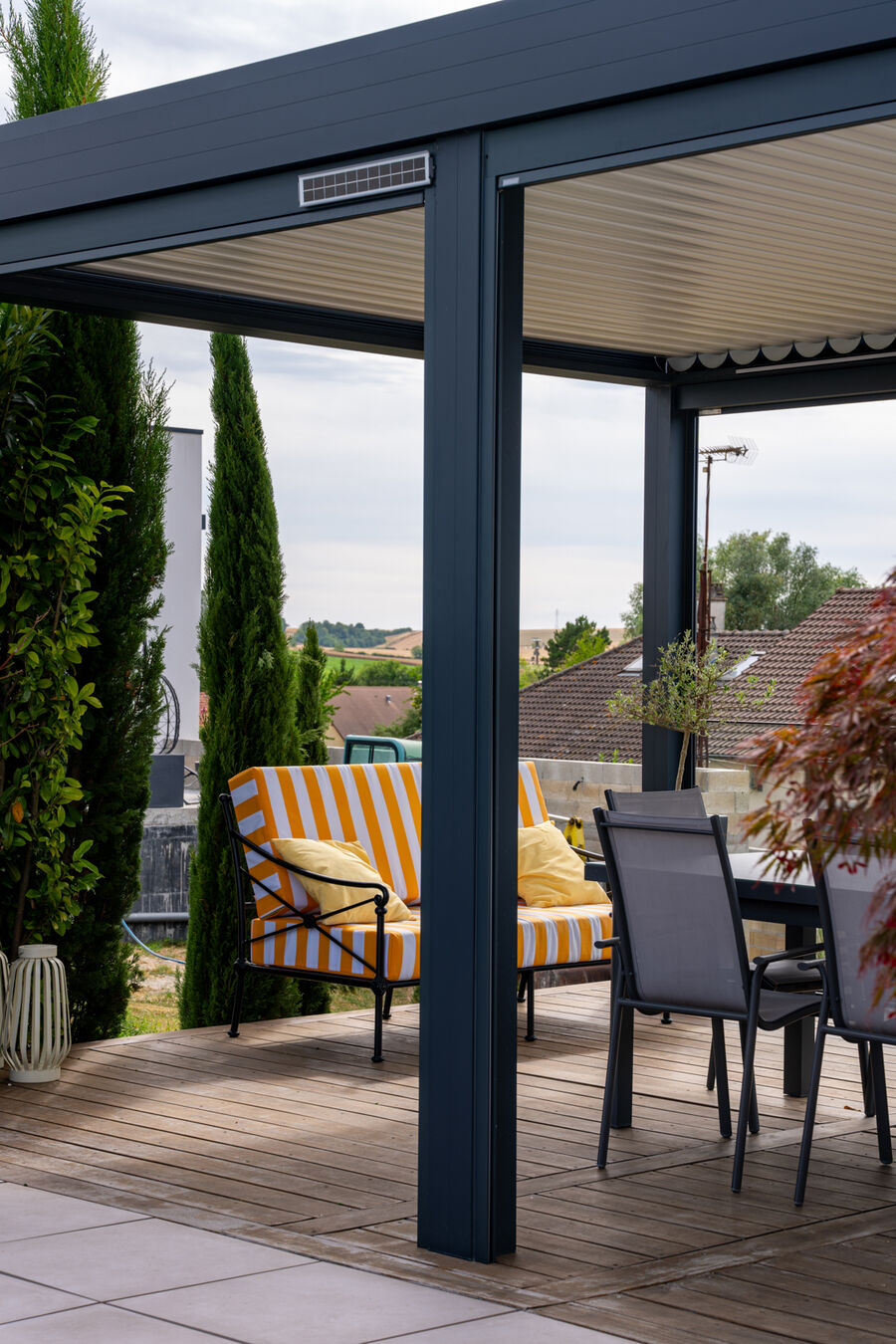 Vue depuis la terrasse sous la pergola avec stores verticaux