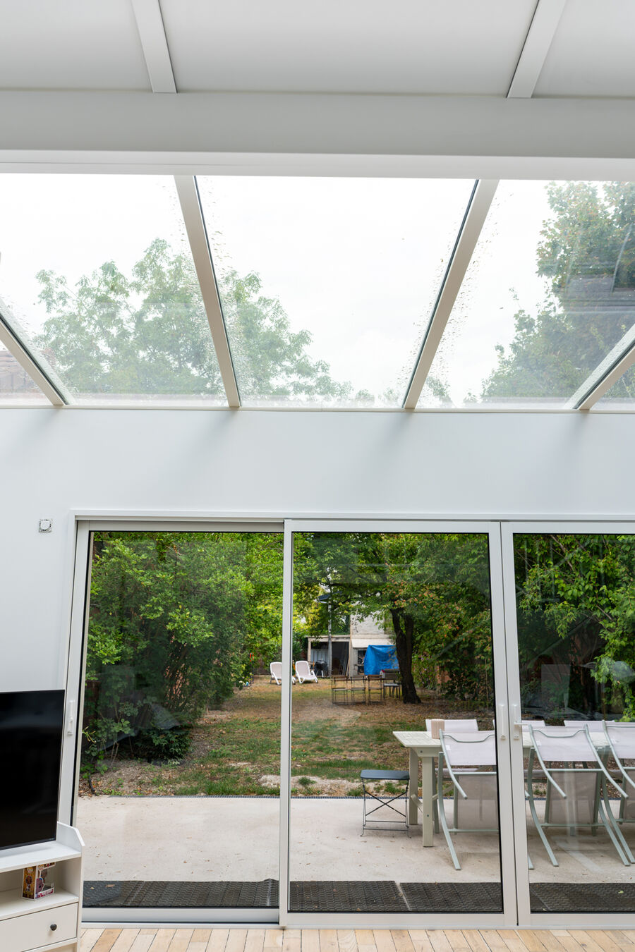 Extension vitrée aluminium avec toiture en verre et baies coulissantes