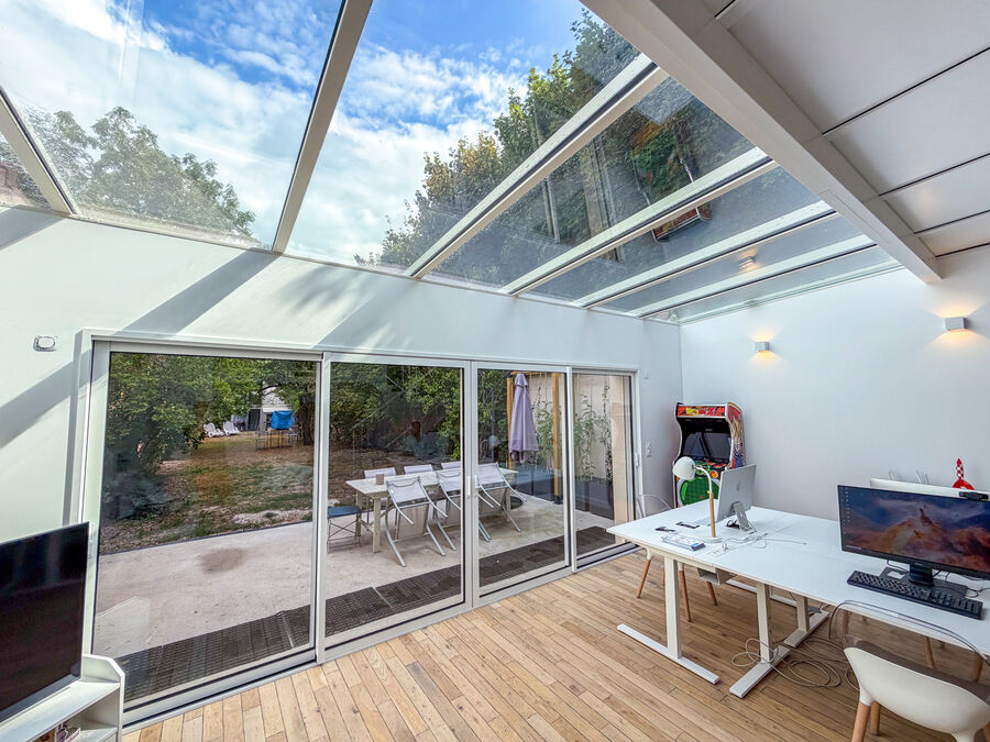 Vue intérieure de l'extension vitrée ouverte sur le jardin